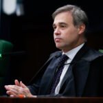 Juiz brasileiro em toga, com as mãos juntas, em tribunal